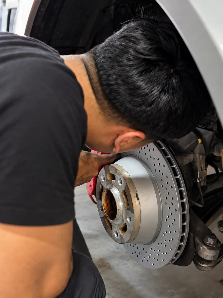 Mecánico de BMCARE Motorsport revisando un disco de freno perforado